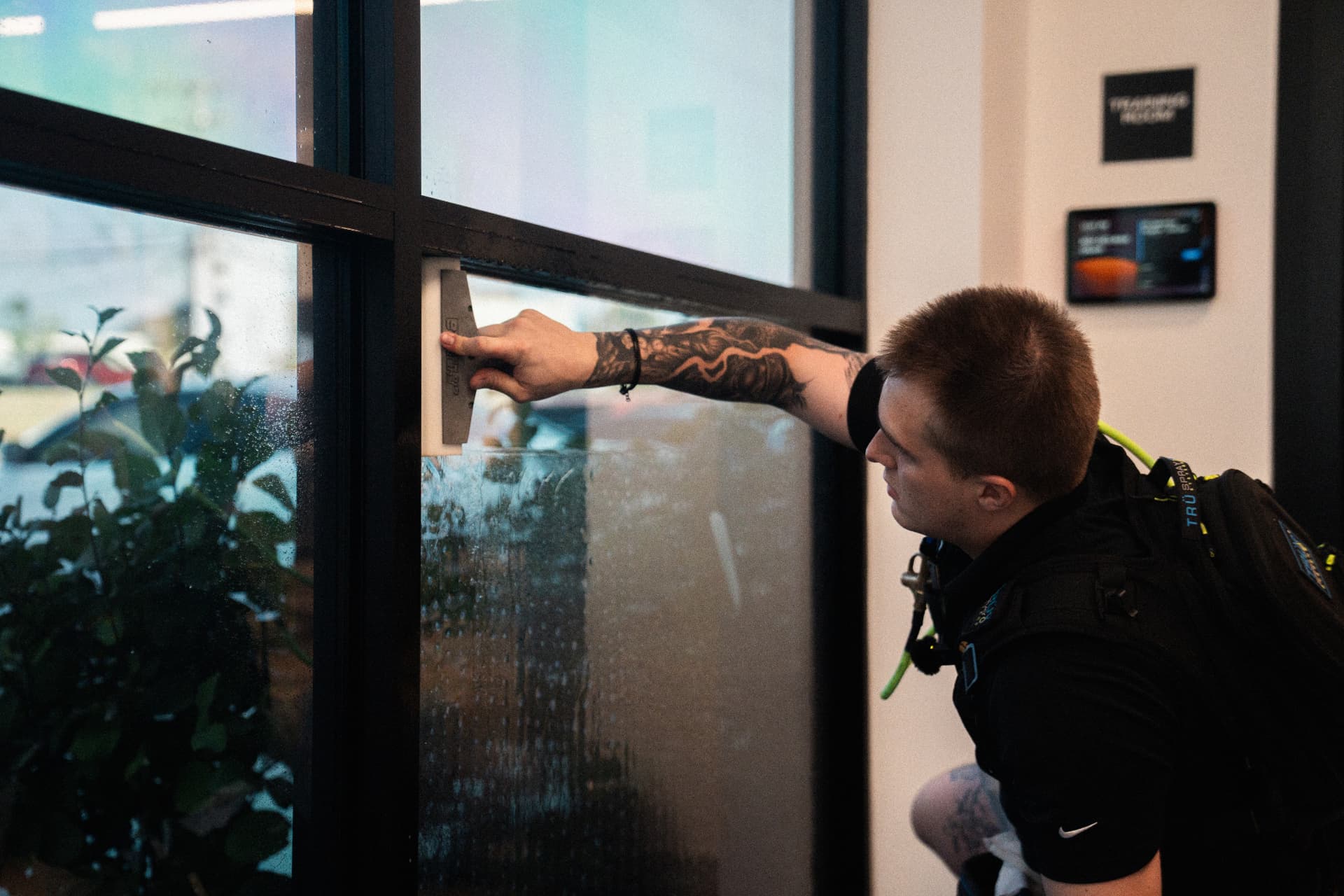 Installer smoothing window film with squeegee