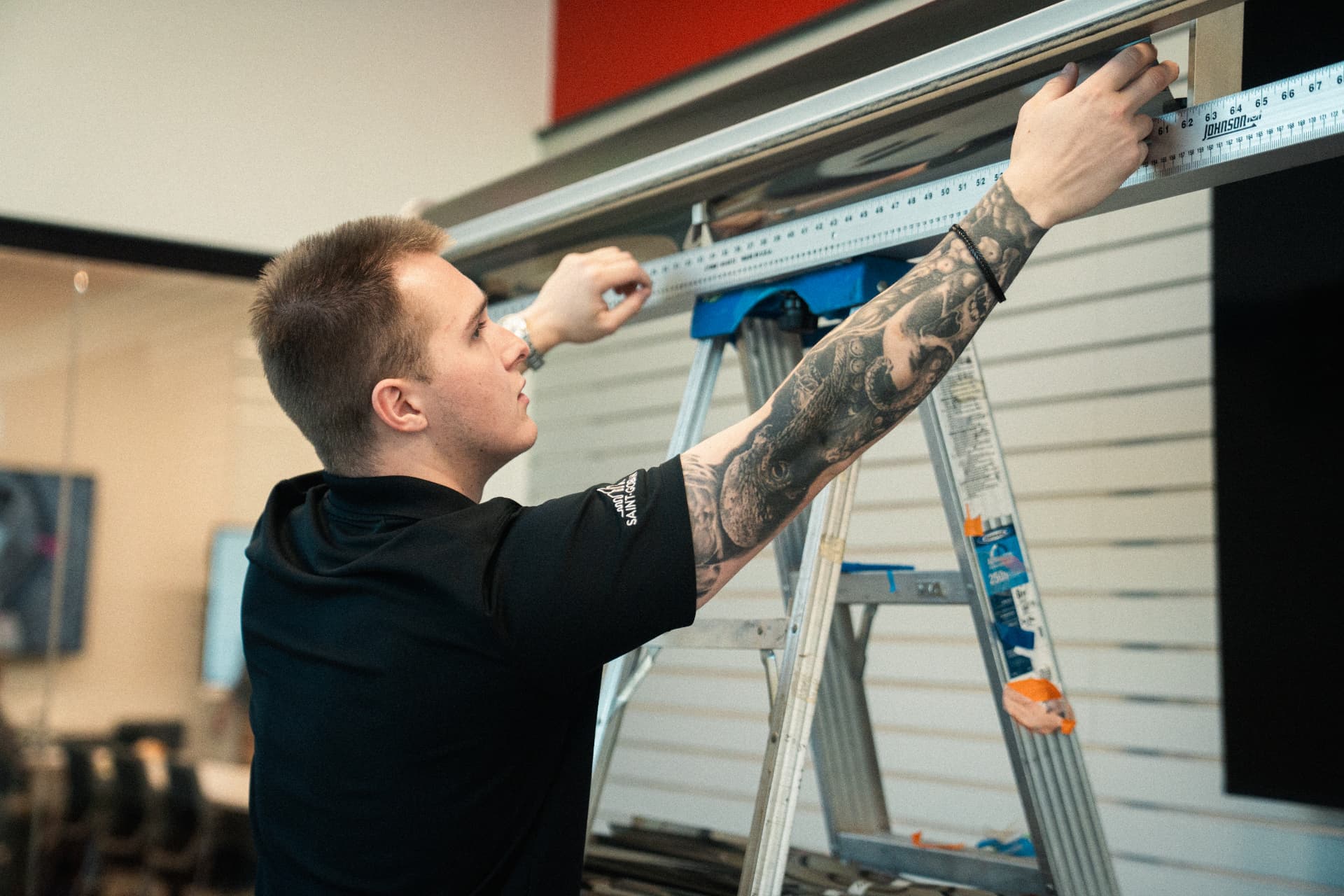 Installer measuring window film on a ladder